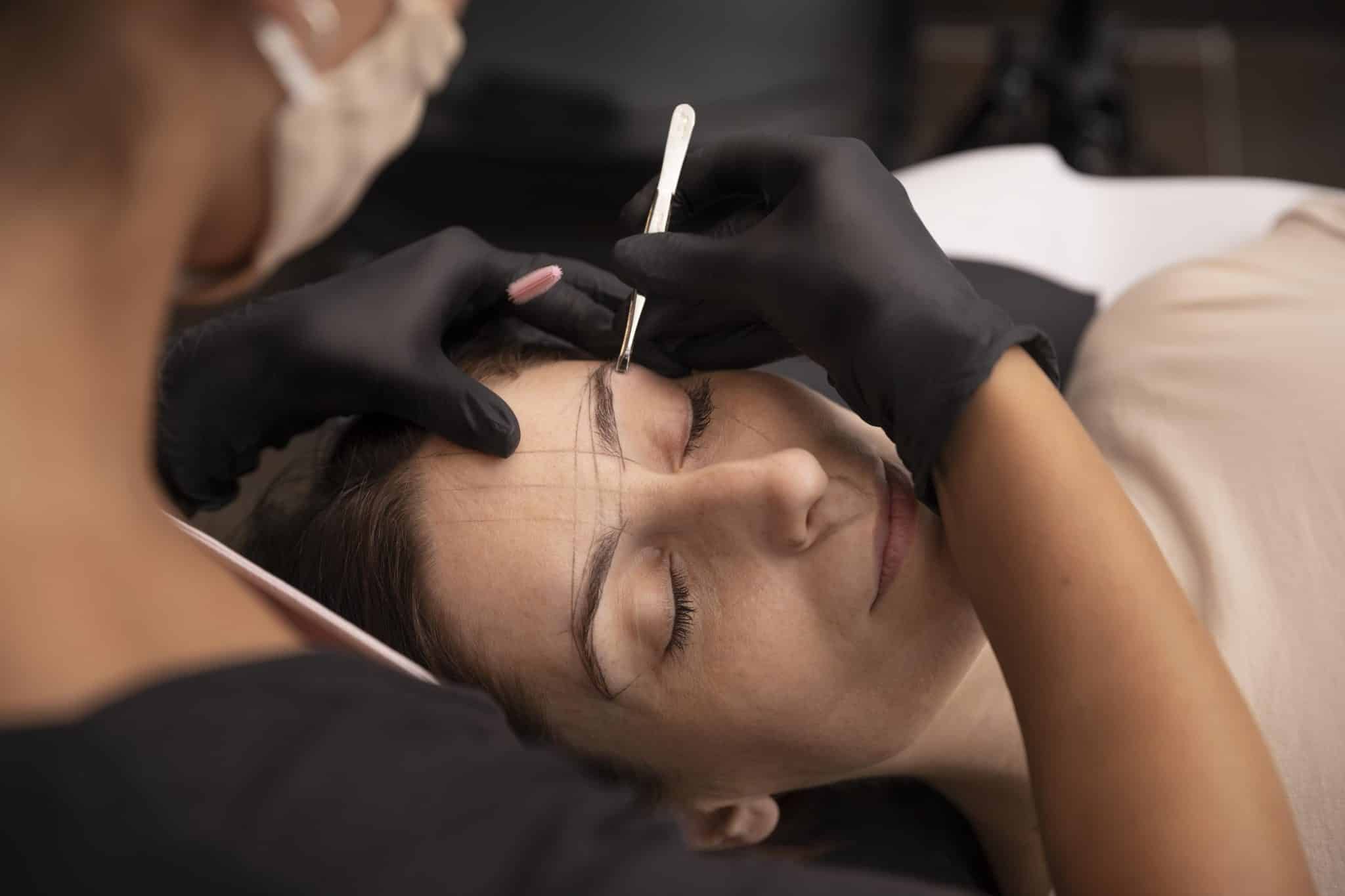 Kvinde behandles af kosmetisk tatovør