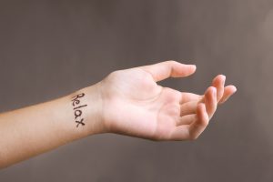 Billede af tatovering på håndled hvor der står Relax