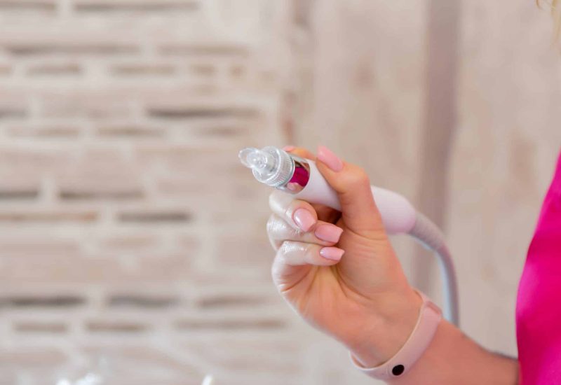 Photo of the Dermapen apparatus in the hands of a beautician. Non-injection mesotherapy procedure. Cosmetic apparatus for lifting and mesotherapy...